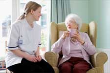 Young nurse chatting with senior woman in care home