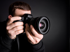 close-up of photographer, with face obscured by camera