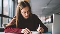 Learner writing at her desk