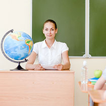Test Administrator sitting at desk in classroom