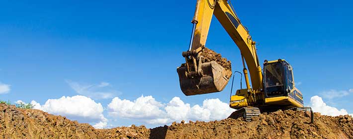 Digger in field moving stones